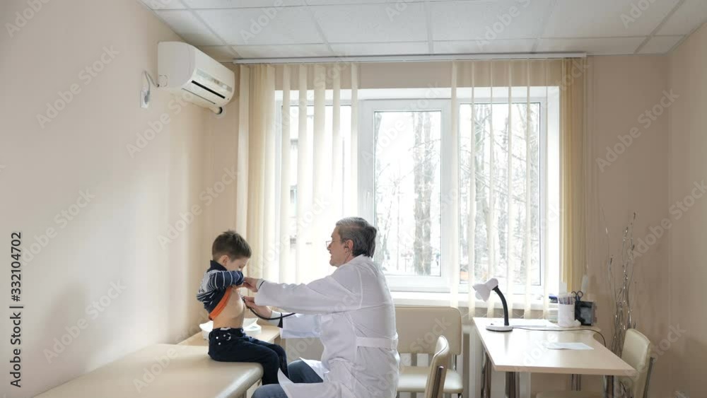 Pediatrician man examining heartbeat of kid boy with stethoscope Pediatrician man examining heartbeat of kid boy with stethoscope