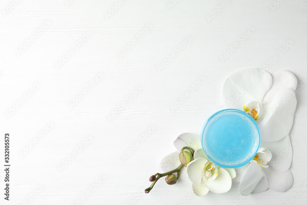 Flat lay composition with cosmetic gel and beautiful flowers on white wooden table. Space for text Flat lay composition with cosmetic gel and beautiful flowers on white wooden table. Space for text