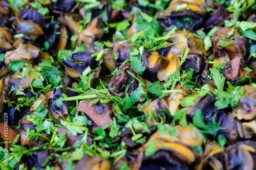 Top view of large portion of freshly cooked mussels and parsley on display for sale at a street food festival, ready to eat healthy seafood