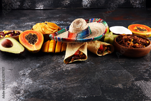 Mexican food mix in colorful colors. sombrero and mexican food with tacos © beats_