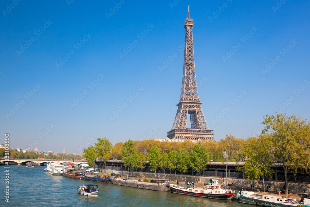 Paris with Eiffel Tower against boats during spring time in France