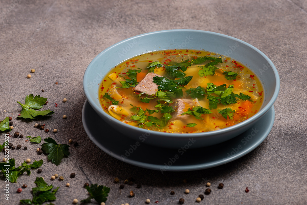 Delicious spicy soup with beef and noodle on grey background.