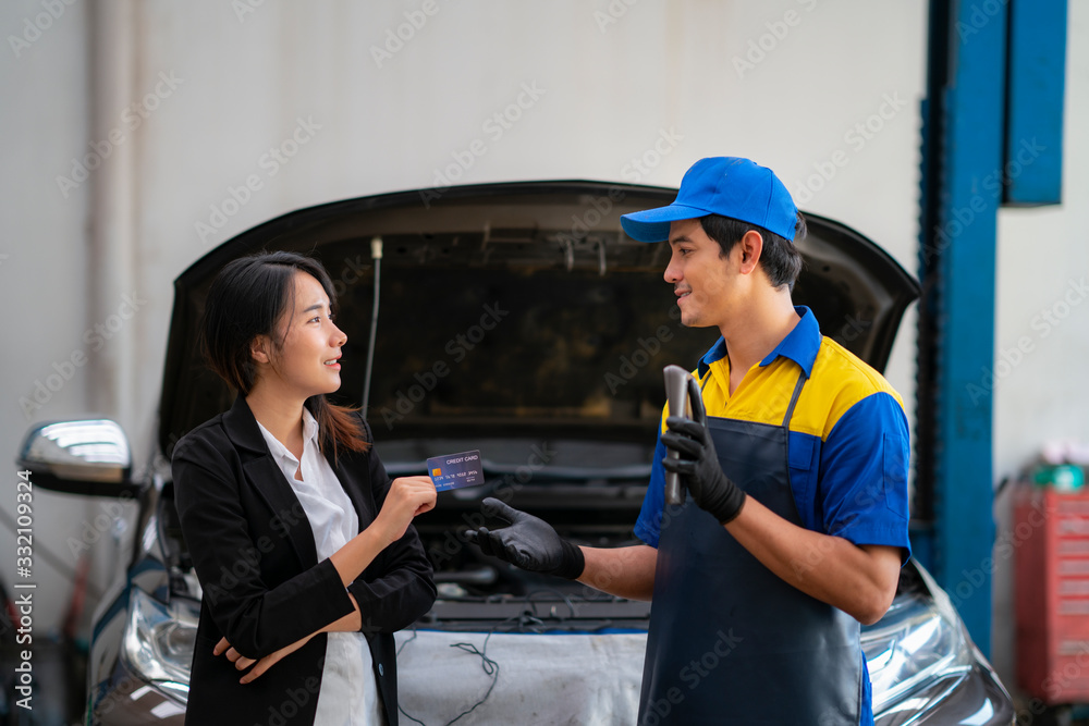 Asian girl pay a car repair cost by a credit card Asian girl pay a car repair cost by a credit card