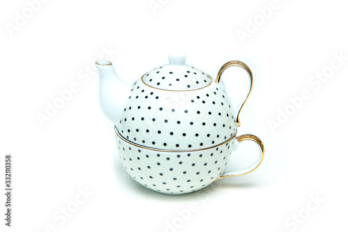 The modern but retro or vintage looking set of dotted tea kettle with a tea cup isolated in a white background.  