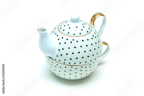 The modern but retro or vintage looking set of dotted tea kettle with a tea cup isolated in a white background.  