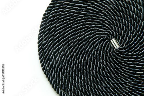 The rolled up black soft bondage rope isolated in a white background. 