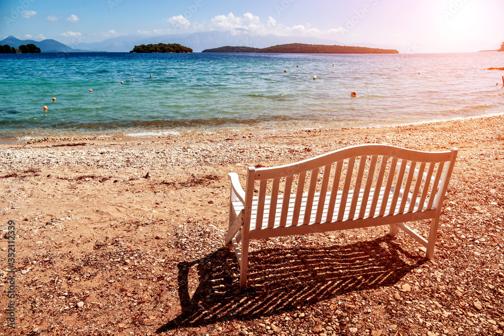 Abstract romantic landscape with a white wooden bench on the coast of the sea in Greece
