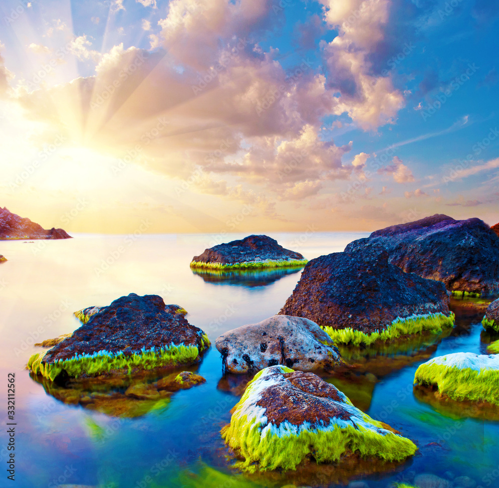 magical beautiful inspiring, picturesque landscape with the sunrise at sea and stones in bright moss. Charming places.