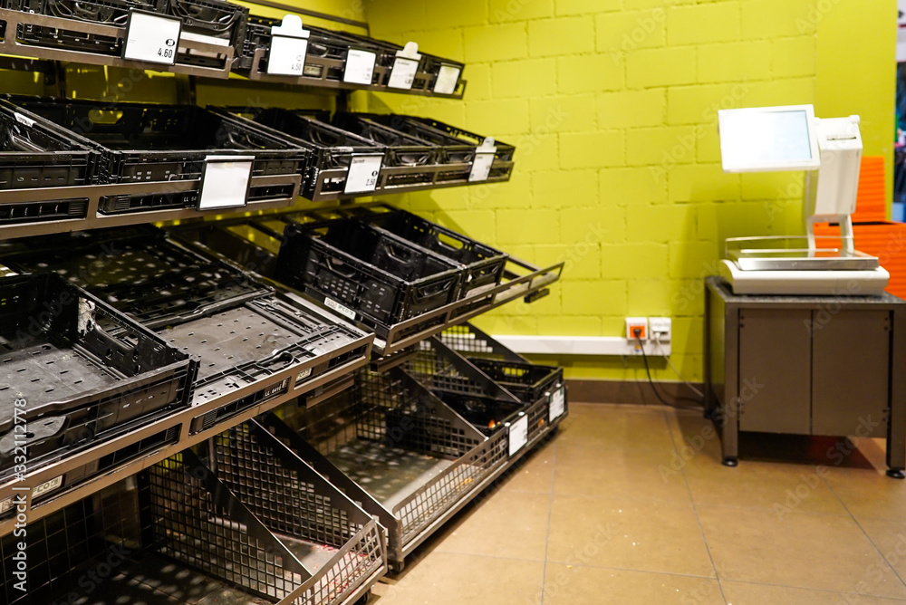 empty fruit and vegetable shelves in a European supermarket after buying food supplies because of Covid-19