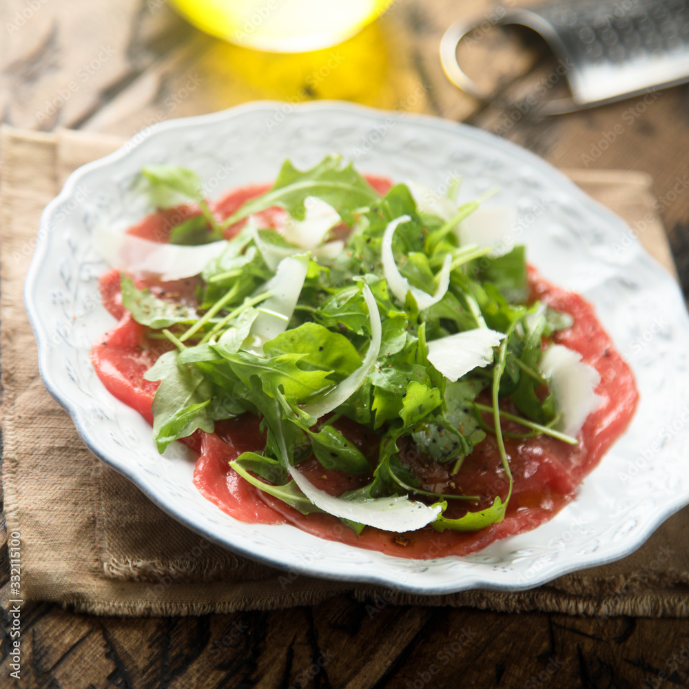 Beef carpaccio with arugula and Parmesan cheese Beef carpaccio with arugula and Parmesan cheese