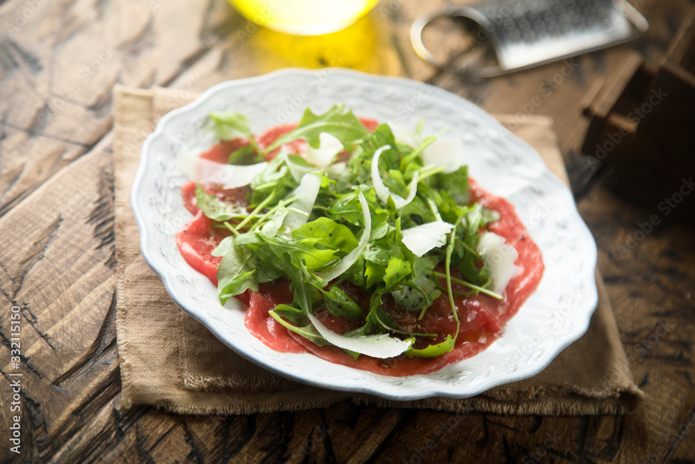 Beef carpaccio with arugula and Parmesan cheese Beef carpaccio with arugula and Parmesan cheese