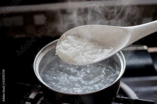 Cooked rice in pot with spoon