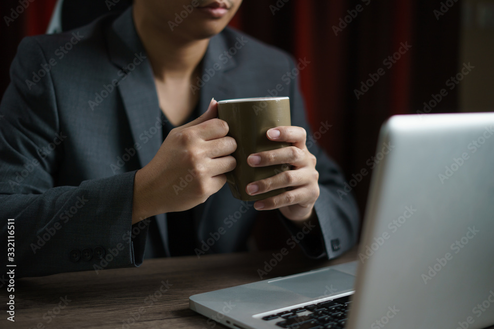 Man working from home using computer and drinking cup of tea, closeup portrait indoor. Man working from home using computer and drinking cup of tea, closeup portrait indoor.