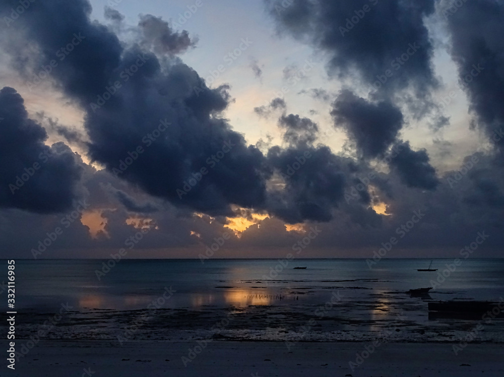 Fototapeta premium Sonnenaufgang, Sonnenuntergang bei Traumkulisse und Fernweh am einsamen Strand auf Sansibar, Fischerboote und Horizont im Hintergrund