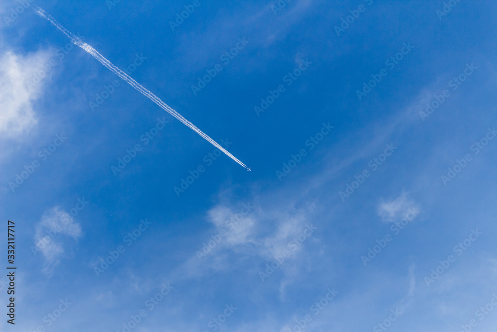 Flying airplane on the blue sky leaving white lines behind Flying airplane on the blue sky leaving white lines behind