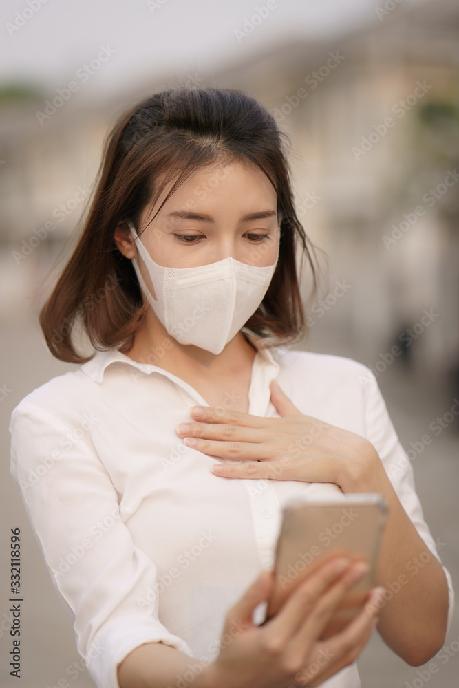 Shocked woman wearing protective mask corona virus (covid-19) use smart phone, worried about the news of the corona virus.