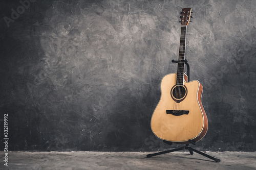 acoustic guitar on gray wall background © Maderla