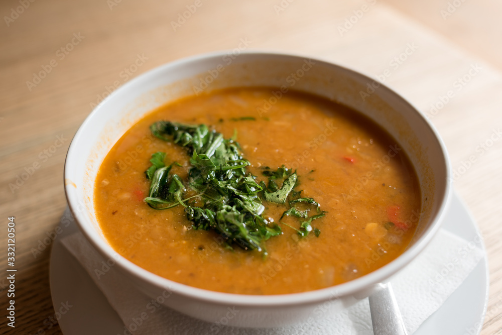 Cream soup garnished with green herbs in white bowl Cream soup garnished with green herbs in white bowl