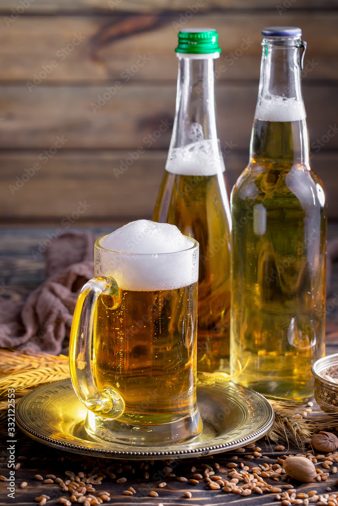 Light frothing beer in a glass, on an old background. Light frothing beer in a glass, on an old background.