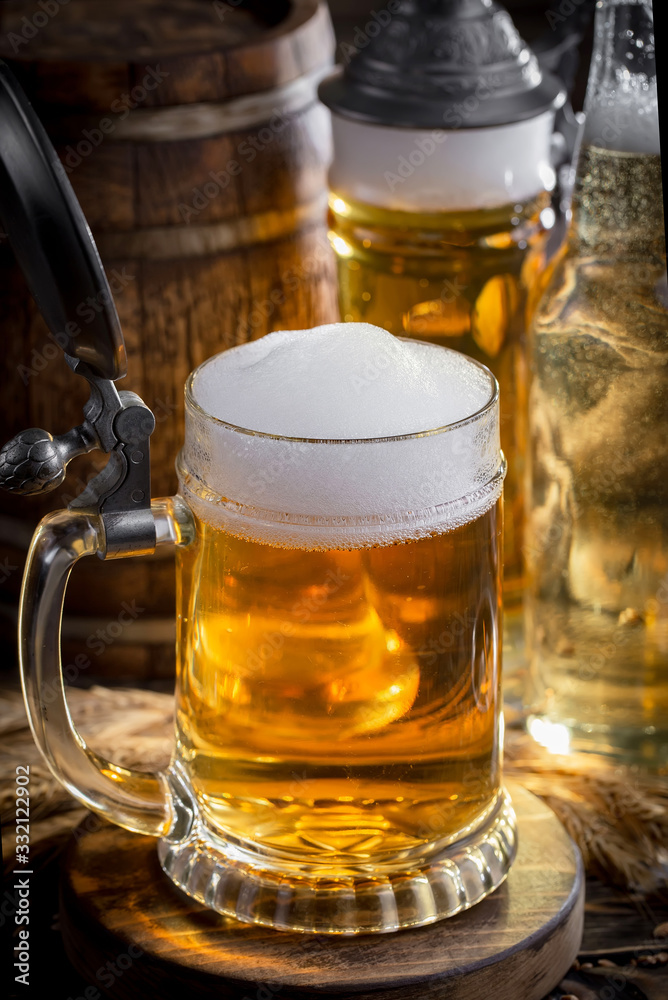 Light frothing beer in a glass, on an old background. Light frothing beer in a glass, on an old background.
