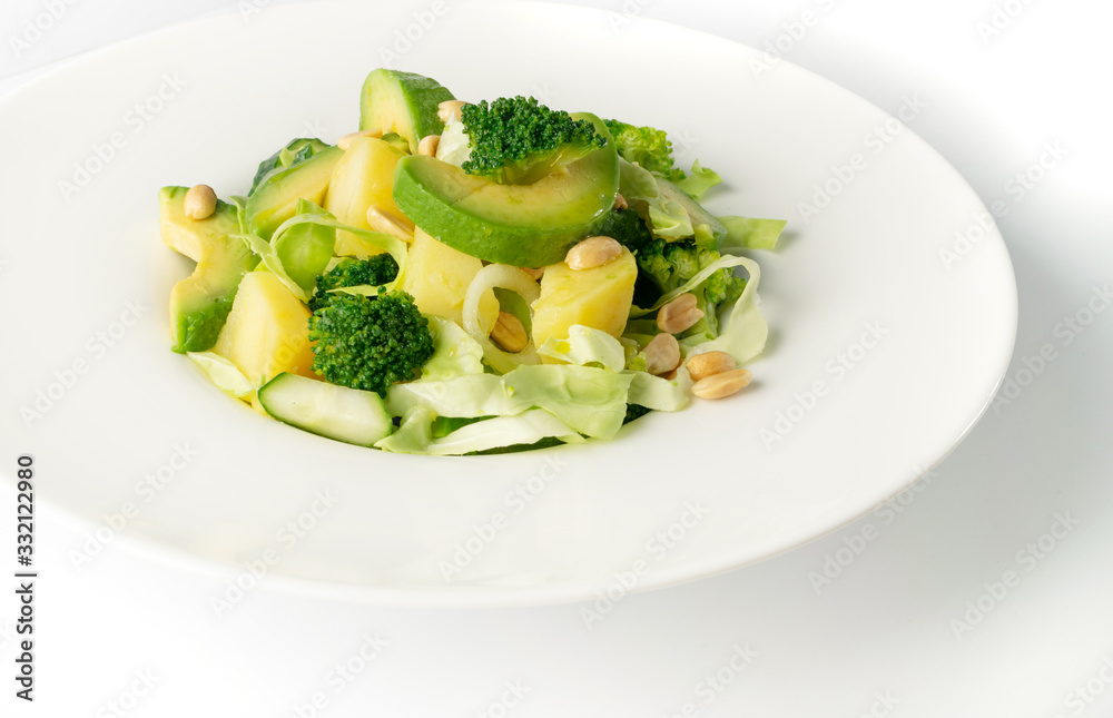 Green Salad with Avocado, Cucumber and Nuts on White Plate Green Salad with Avocado, Cucumber and Nuts on White Plate