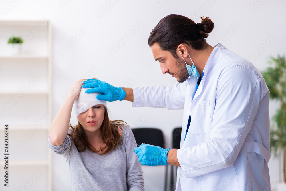 Young head injured woman visiting young male doctor Young head injured woman visiting young male doctor
