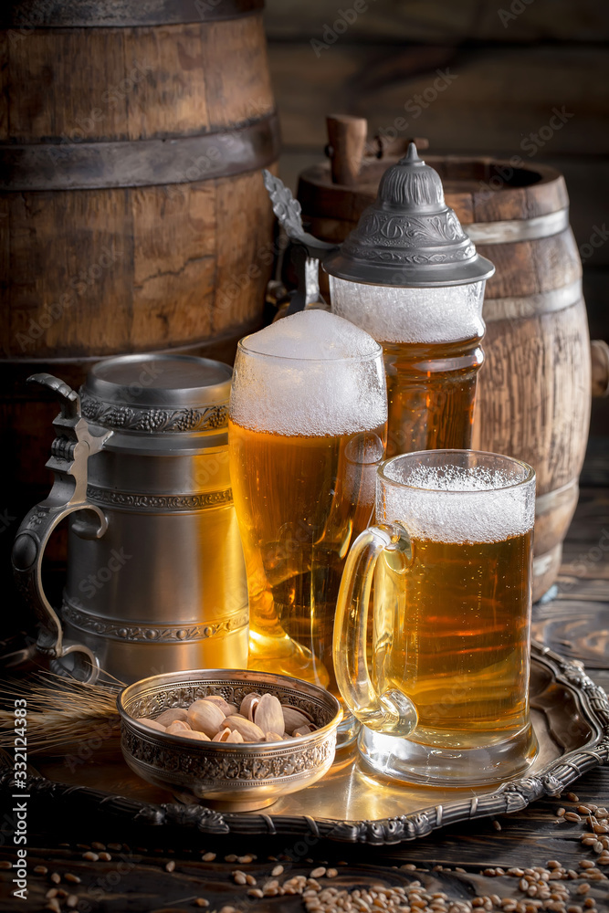 Light frothing beer in a glass, on an old background.