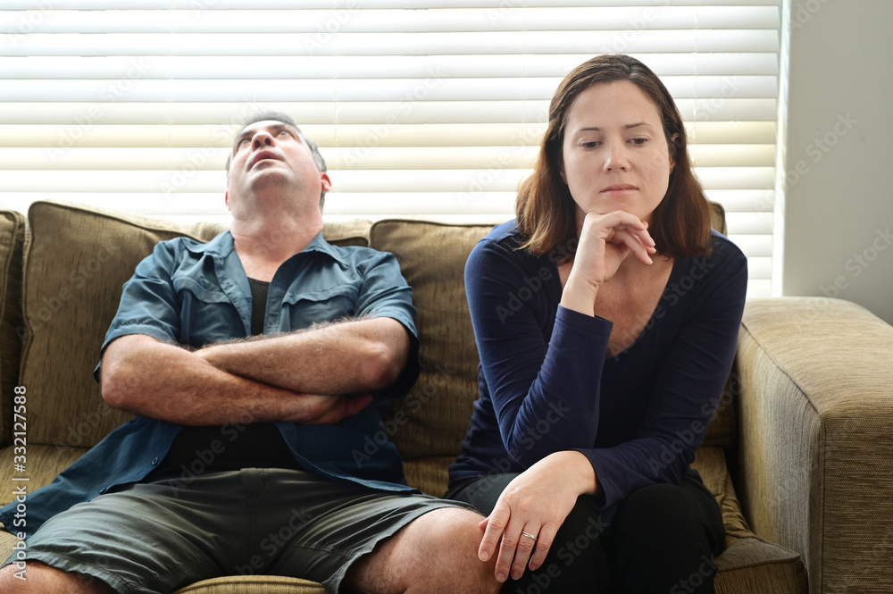 Obraz premium Sad adult couple forced to stay at home as the pandemic coronavirus (COVID-19) forces many people to stay at home because new government policies