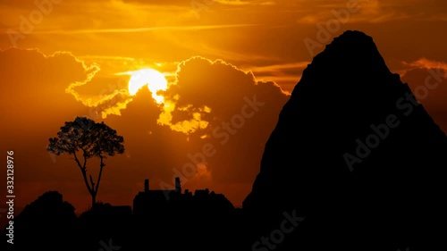 Machu Picchu: Ruins of Ancient Inca City, Time Lapse at Sunset with Red Clouds, Fiery Sky and Dark Silhouette of Mountains, Peru photo