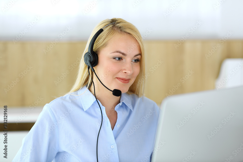 Call center. Blonde business woman sitting in headset at customer service office. Concept of telesales business or home office occupation Call center. Blonde business woman sitting in headset at customer service office. Concept of telesales business or home office occupation