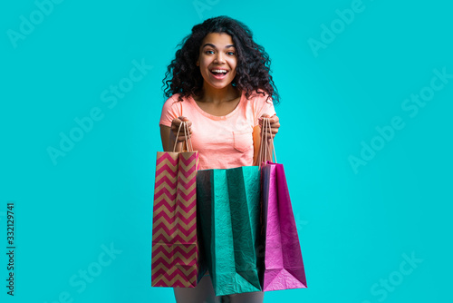 Attractive young dark skinned woman with a bunch of shopping bags