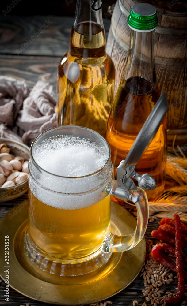Light beer in a glass on a table in composition with accessories on an old background Light beer in a glass on a table in composition with accessories on an old background
