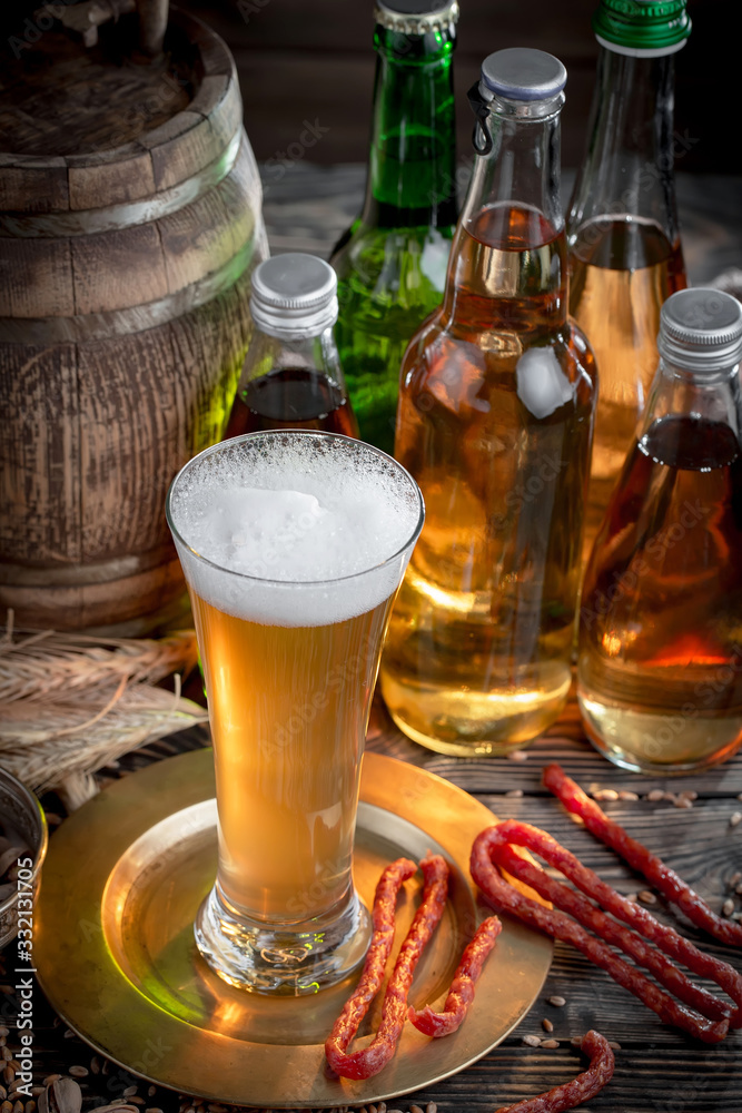 Light frothing beer in a glass, on an old background. Light frothing beer in a glass, on an old background.