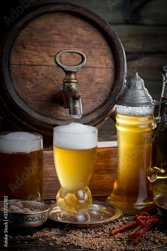 Light frothing beer in a glass, on an old background.