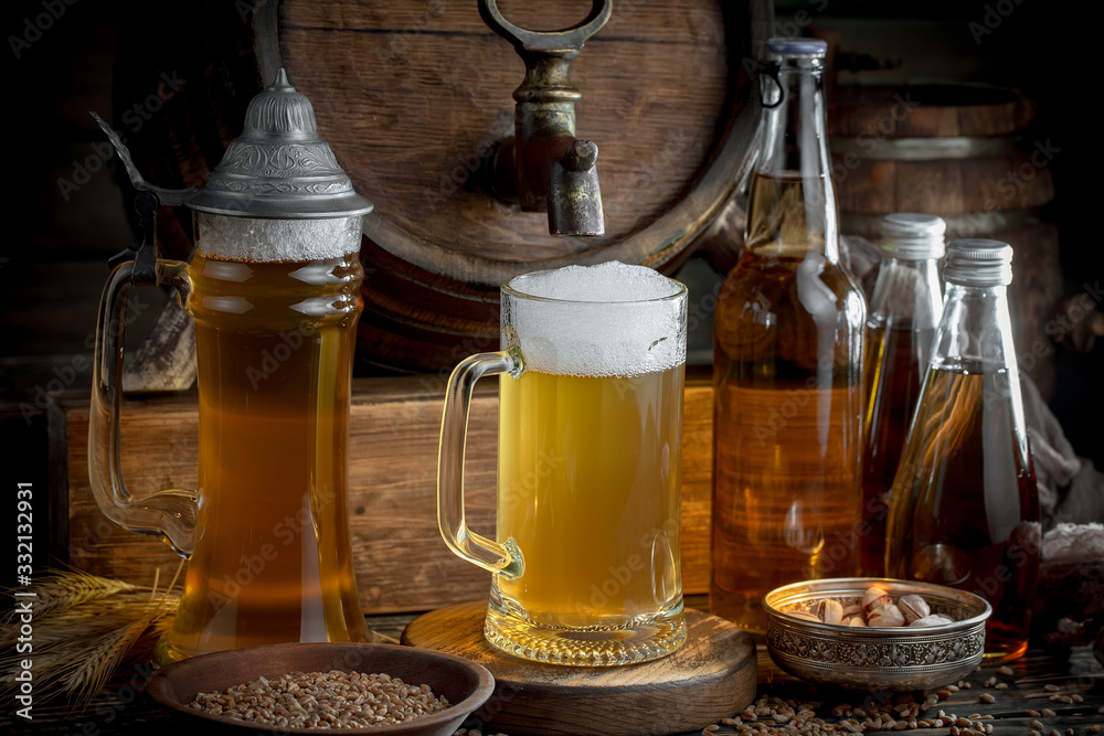 Light frothing beer in a glass, on an old background. Light frothing beer in a glass, on an old background.