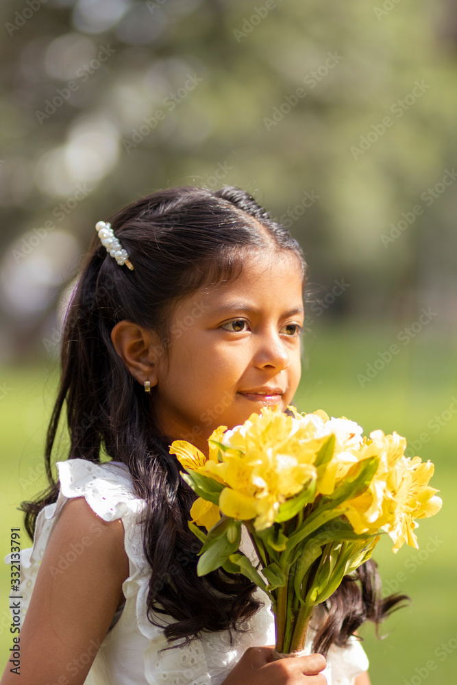 Little girl in white dress and with a cute bouquet of flowers in her hand Little girl in white dress and with a cute bouquet of flowers in her hand