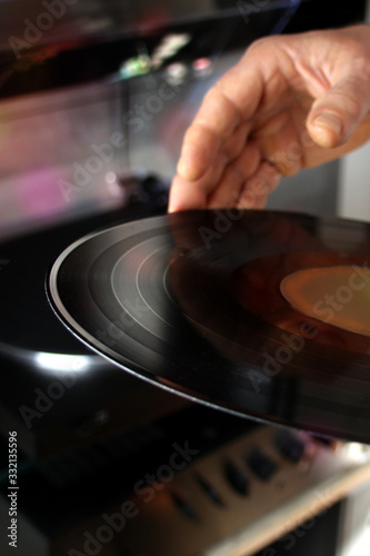 black vinyl music disc for the player in male hands, the concept of retro music, lifestyle
