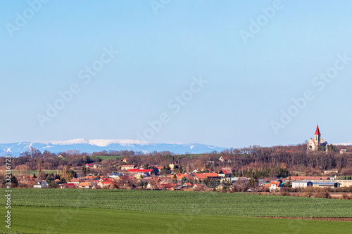 Czech village with Church and mountains in back.
