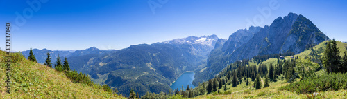 Aerial view of Lake Gosau, Gosausee, Austria. Behind famous mount Dachstein and its glacier are visible. Sunny summerday with no clouds visible. On the right the mountain range Gosaukamm is visible.