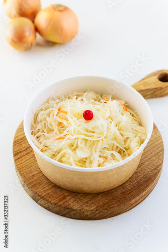 Sauerkraut with cranberries on a wooden board. Fermented food concept.