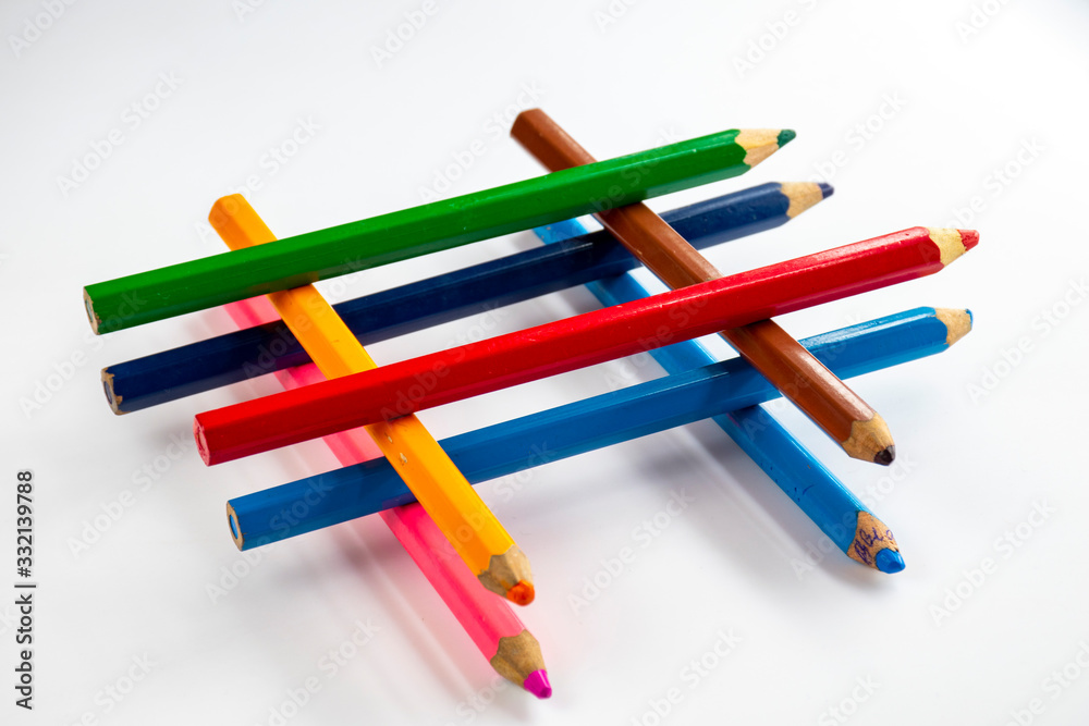 Multicolored pencils on a white background close-up. Multicolored pencils on a white background close-up.
