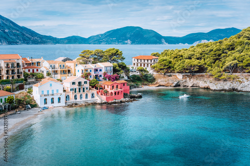 Holiday vacation on Kefalonia, Greece. Blue sea bay in front of Assos village. Beautiful view to vivid colorful houses near blue turquoise colored transparent bay lagoon