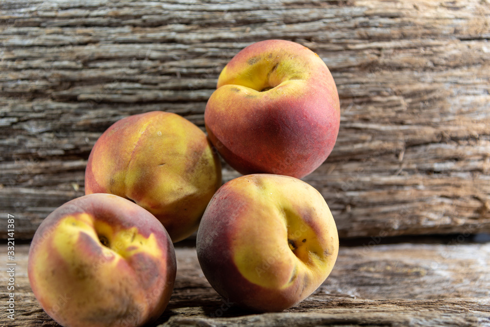 Peach fruits (Prunus persica) in natura on a woody background Peach fruits (Prunus persica) in natura on a woody background