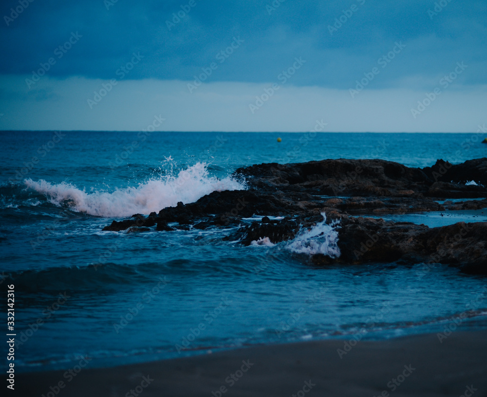 waves on the Mediterranean sea at night on the beach