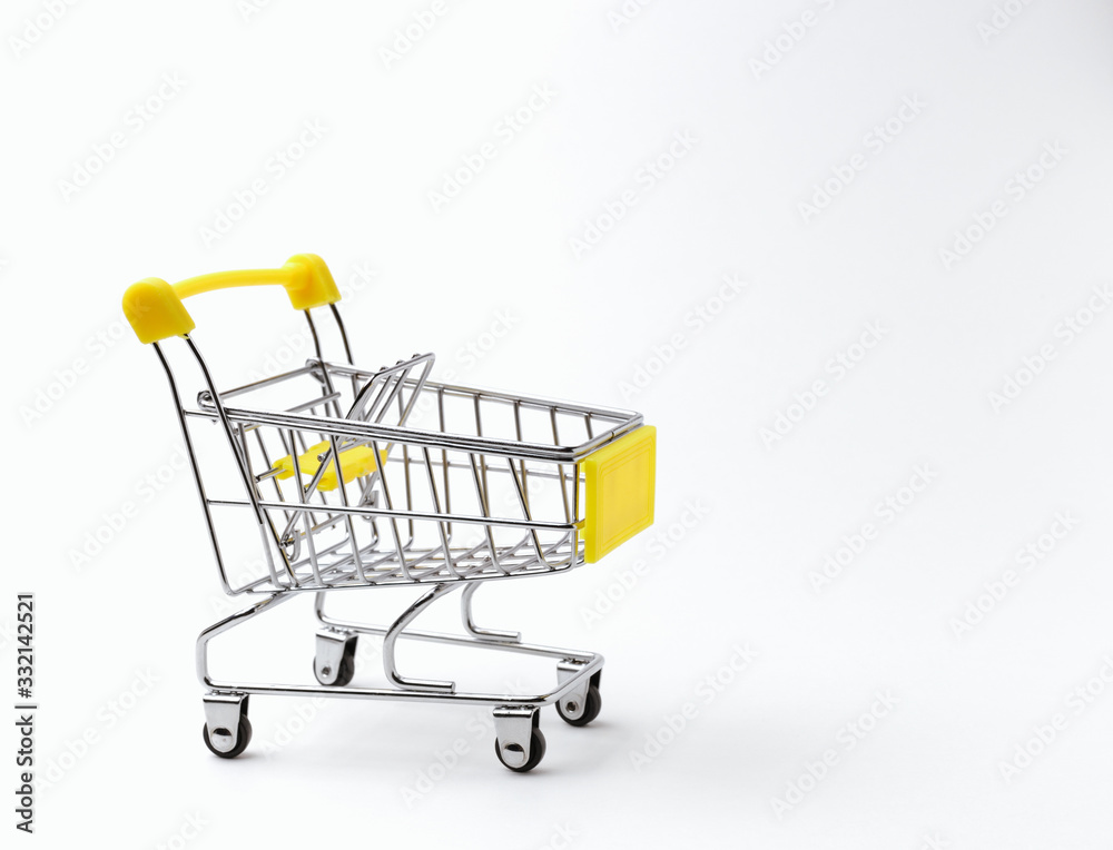 An empty shopping cart with a yellow handle on a white background. Space for text. Side view An empty shopping cart with a yellow handle on a white background. Space for text. Side view