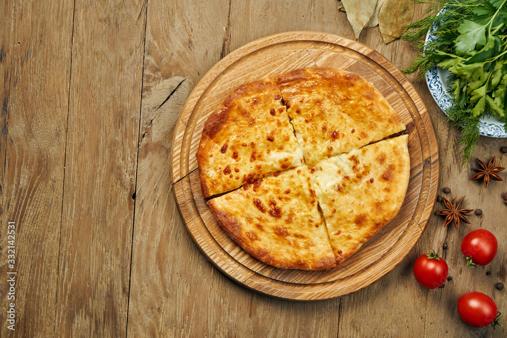 Close up view on tasty traditional Khachapuri - closed baked pie stuffed with melted salt cheese (suluguni) or meat on wooden tray. Traditional georgian food Close up view on tasty traditional Khachapuri - closed baked pie stuffed with melted salt cheese (suluguni) or meat on wooden tray. Traditional georgian food