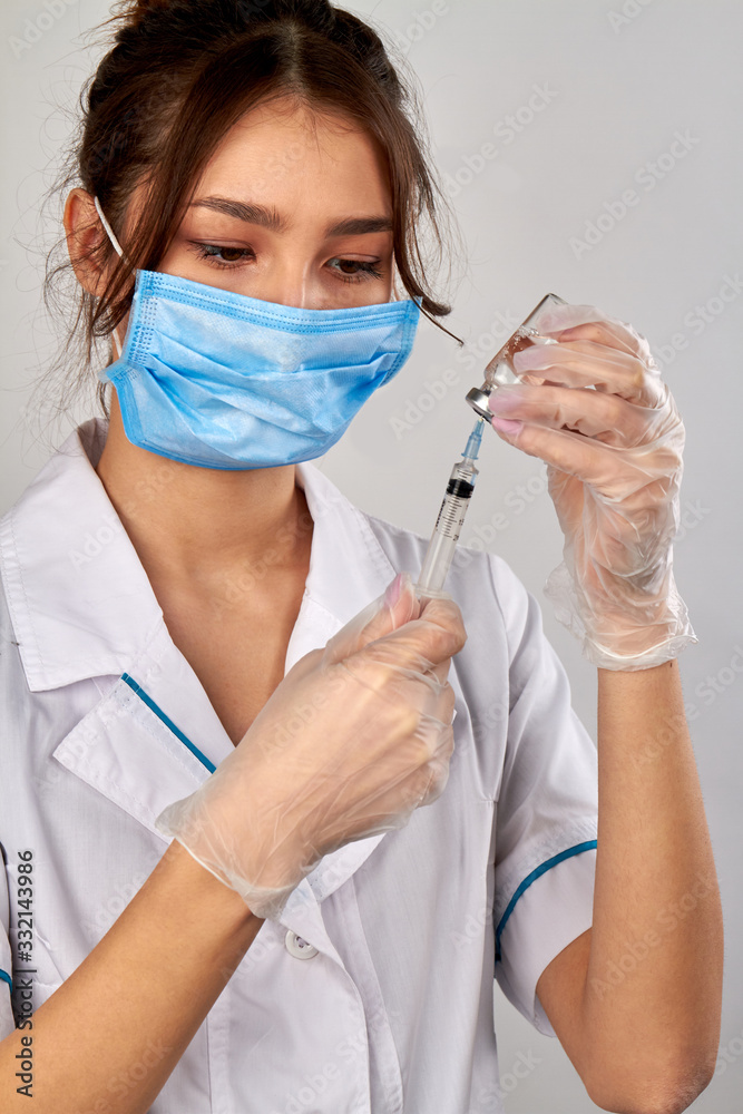 Female doctor filling syringe with medicine from the vial tube. Healthcare and injection concept. Isolated on white background. Female doctor filling syringe with medicine from the vial tube. Healthcare and injection concept. Isolated on white background.