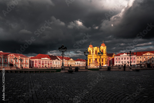 TIMISOARA, ROMANIA - SEPTEMBER 3, 2019: child who runs after the pigeon in Unirii Square of Timisoara. stormy day photo