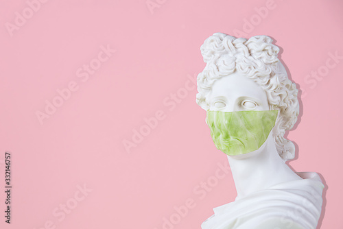 Antique statue with antiviral mask for protection against coronavirus.