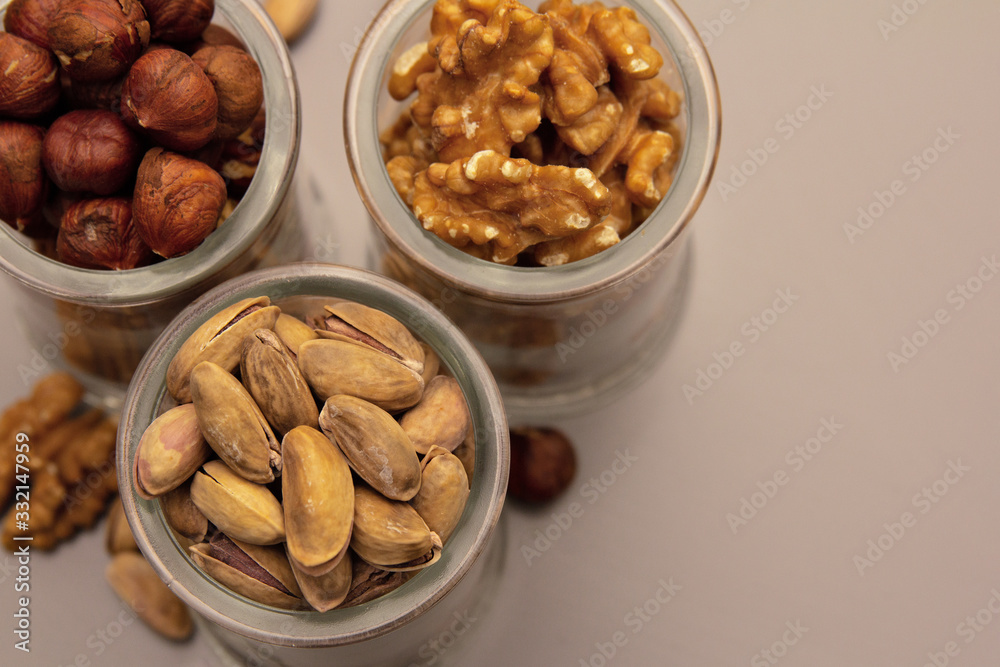 hazelnut, walnut and pistachio nut. mixed assorted nuts in glass box on light background. hazelnut, walnut and pistachio nut. mixed assorted nuts in glass box on light background.